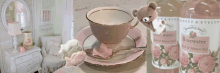 a bottle of rosewater sits on a table next to a cup and saucer