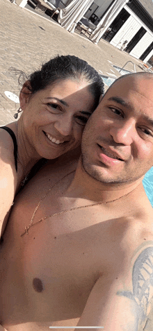 a man and a woman are posing for a picture by a pool