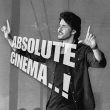 a man smoking a cigarette in front of a sign that reads absolute cinema