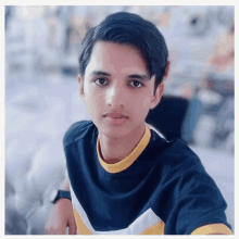 a young man wearing a black shirt with a yellow and white stripe on the sleeves