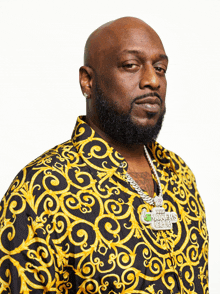 a man wearing a black and gold shirt with a necklace that says smokey 's club