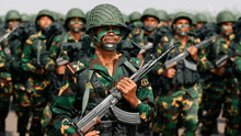 a group of soldiers are marching in a line holding guns .