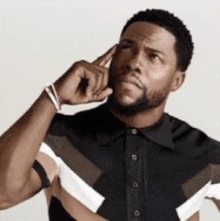 a man with a beard is wearing a black and white striped shirt and thinking .