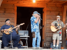 a man singing into a microphone while another man plays guitar