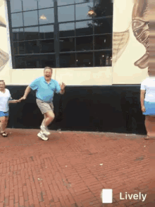 a man in a blue shirt is dancing on a brick sidewalk in front of a building that says lively on the bottom