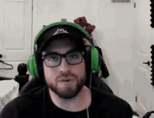 a man with a beard is wearing headphones and a hat .