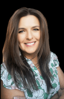 a woman in a floral shirt is smiling for the camera