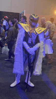 a man in a power ranger costume is holding a cane and wearing a name tag