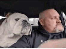 a man and a dog are sitting in a car .