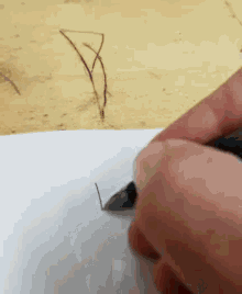 a person is drawing a triangle with a pen