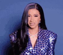 cardi b is wearing a blue checkered jacket and a necklace