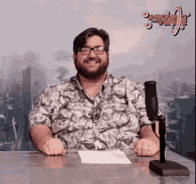 a man sitting at a desk with a microphone in front of a sign that says ' around the corner '