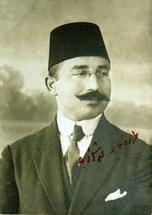 a black and white photo of a man with a mustache and glasses