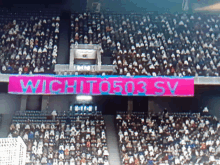 a crowd of people in a stadium with a banner that says wichita503 sv