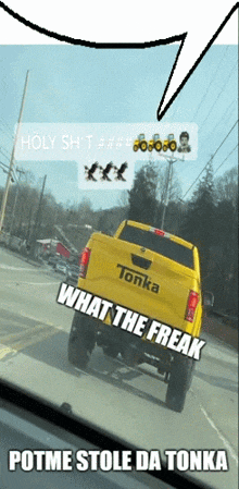 a yellow tonka truck is driving down a street