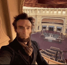 a man with a beard is taking a selfie in front of a building