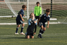 a group of young boys are playing soccer on a field and one of them is wearing a jersey that says adidas on it