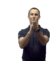 a man wearing a black polo shirt and a watch is clapping his hands