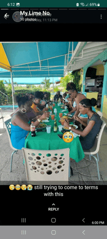 a group of people are sitting at a long table eating