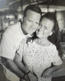 a man and a woman are posing for a picture and the woman is smiling