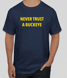 a man is wearing a blue shirt that says never trust a buckeye