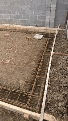 a brick wall is behind a concrete slab with a wooden frame