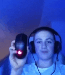 a young man wearing headphones is holding a computer mouse .