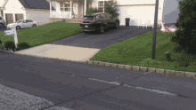 a black car is parked in front of a white house with a mailbox that says ' a ' on it