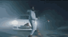 a man in a white suit is walking in front of a white car