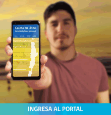 a man holds up a cell phone that says caleta en linea on the screen