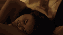 a close up of a woman sleeping on a bed