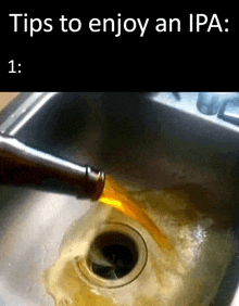 a bottle of beer is being poured into a kitchen sink