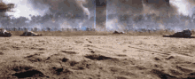 a group of soldiers are laying on the ground in a field with smoke coming out of the sky .