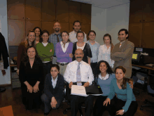 a group of people posing for a picture with a man holding a book that says ' executive ' on it