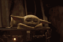 a baby yoda is laying in a metal container