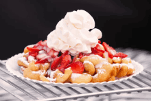 a plate of food with whipped cream and strawberries on top