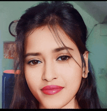 a close up of a girl 's face with a clock in the background