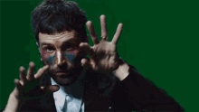 a man with paint on his face is wearing a ring on his finger