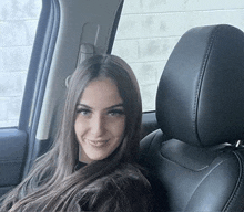 a woman is sitting in the back seat of a car .