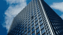 looking up at a skyscraper with a blue sky in the background