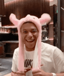 a man wearing a pink hat with bunny ears is smiling