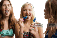 three young girls are sticking their tongues out and eating popsicles