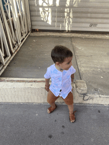 a little boy standing in front of a garage door that says lv