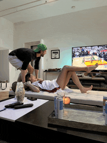 a man and a woman are watching a basketball game on a tv