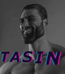 a shirtless man with a beard is smiling in a black and white photo with the word tasin on the bottom right