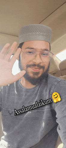 a man wearing glasses and a hat with the words assalamualaikum on his shirt