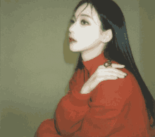 a woman wearing a red sweater has a ring on her left shoulder