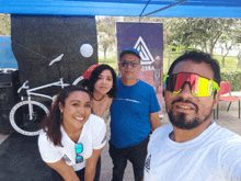 a group of people posing for a picture in front of a sign that says " a "