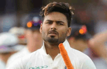 a man with a beard wearing a white shirt with the word oppo on it