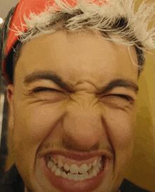 a close up of a man 's face with a red headband on